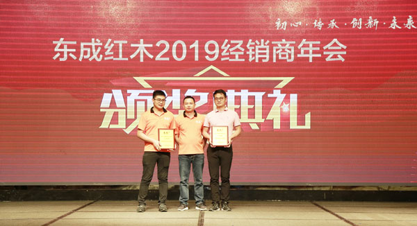 东成红木品牌总监阮家鹏（中）为“东成红木2018年度最佳服务经销商”颁奖