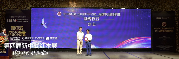 中山市民政局副局长杨晓鹏（左）为中山市红木古典家具学会第二届会长、弘木传媒CEO林伟华（右）颁牌