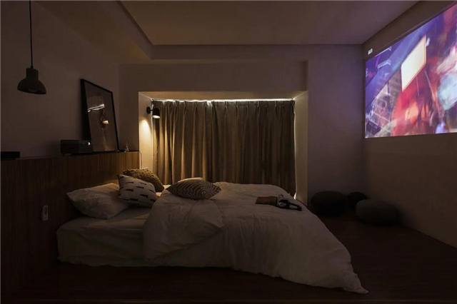 床尾的大白墙,投影仪的画面直接投射在上面,让卧室在夜晚就成为一个